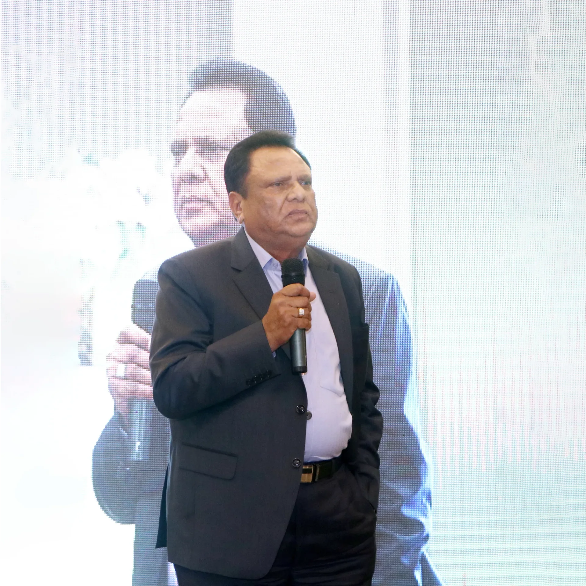 Shri Suresh Pal in a suit, smiling in an armchair