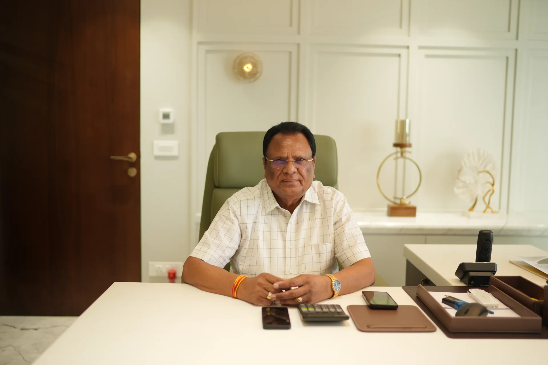 Shri Suresh Pal seated at his office desk, the founder of SM Pal Group