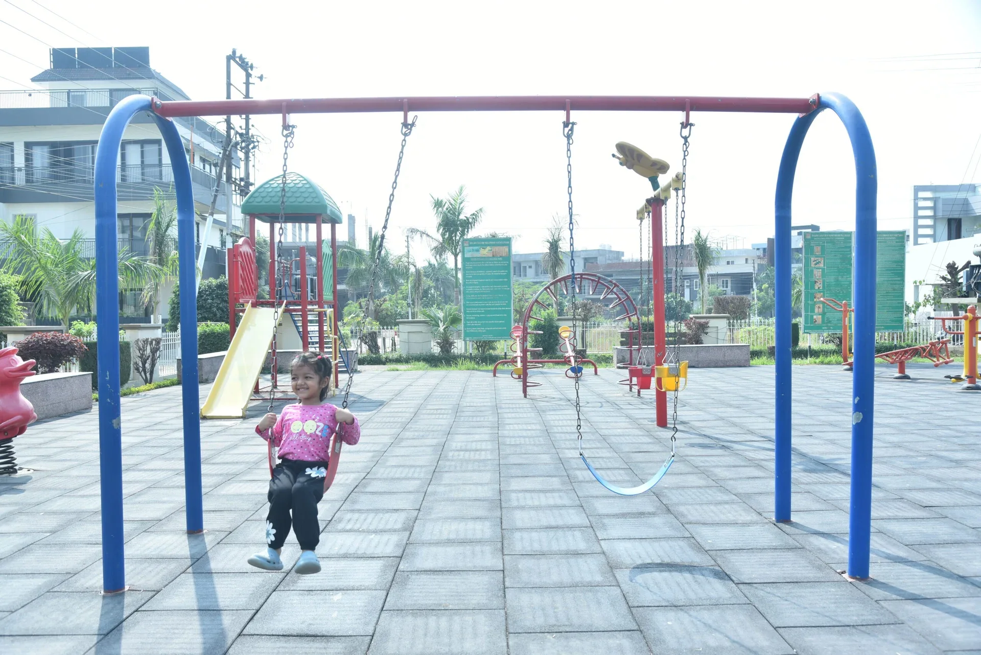 Swings and landscaped surroundings in the Palam City park