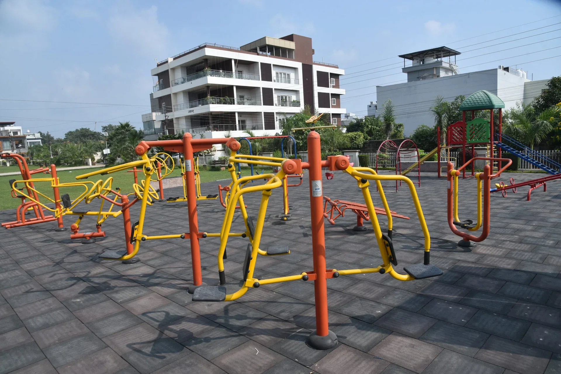 Outdoor exercise equipment beside the green grounds and play area